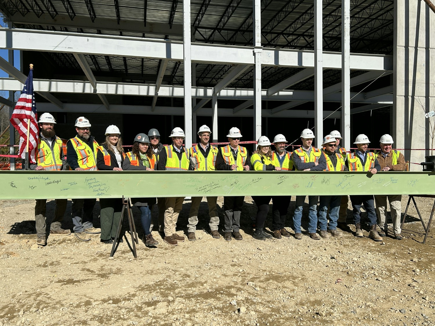 Our team celebrates the completion of the structure with a topping out ceremony by lifting the final beam into place.