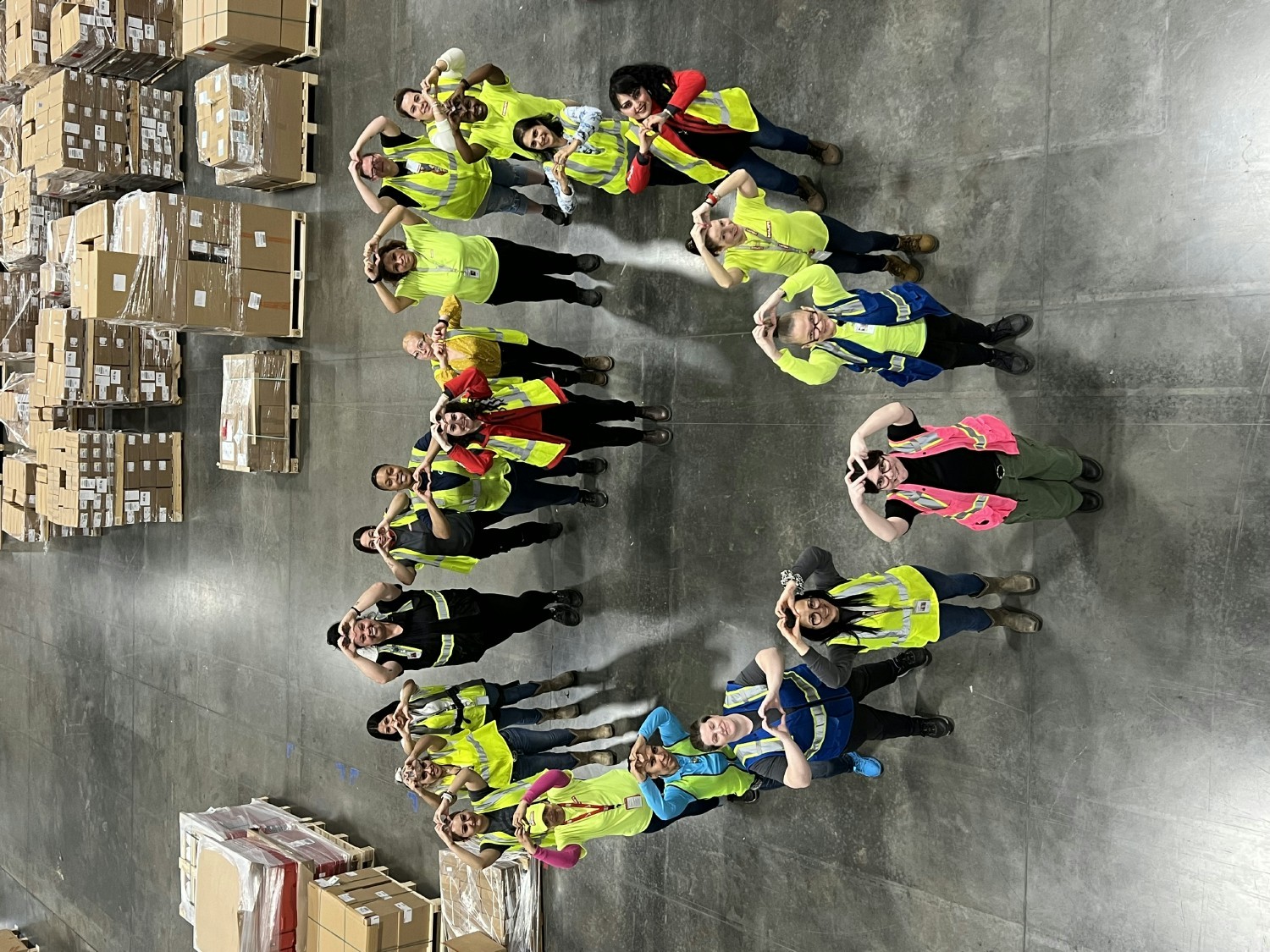 Team members at a distribution center making a heart for International Women's Day 2024