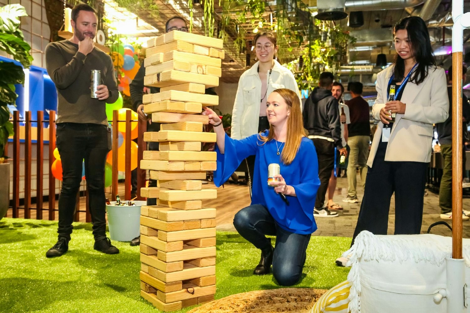 Employees enjoying a friendly game of giant Jenga during an office party.  