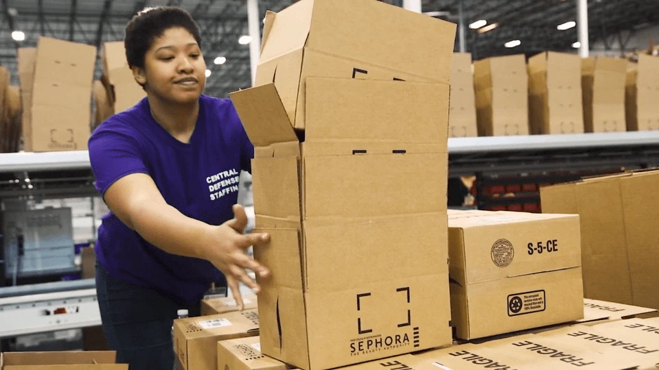 Sephora distribution center employee preparing boxes for shipping.