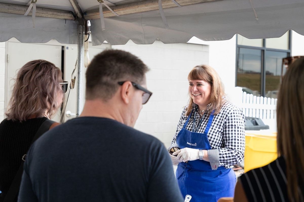 Chief Revenue Officer, Katy Cohen serves lunch during the annual summer picnic.