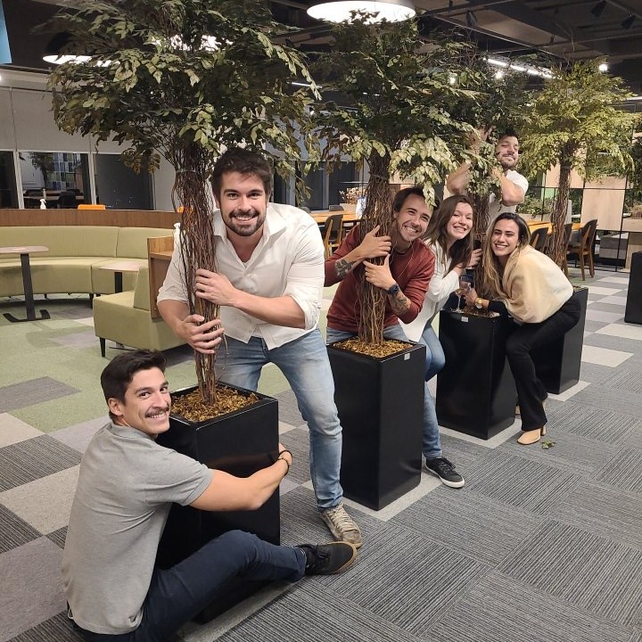 Our colleagues demonstrating their commitment to sustainability by hugging trees in the office