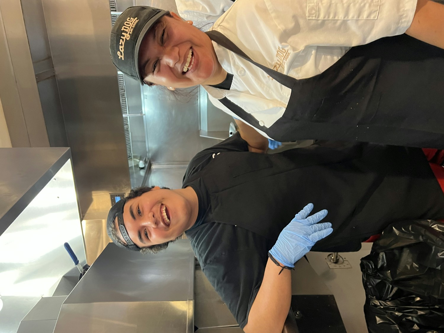 Laughs and smiles behind the line during culinary training. 