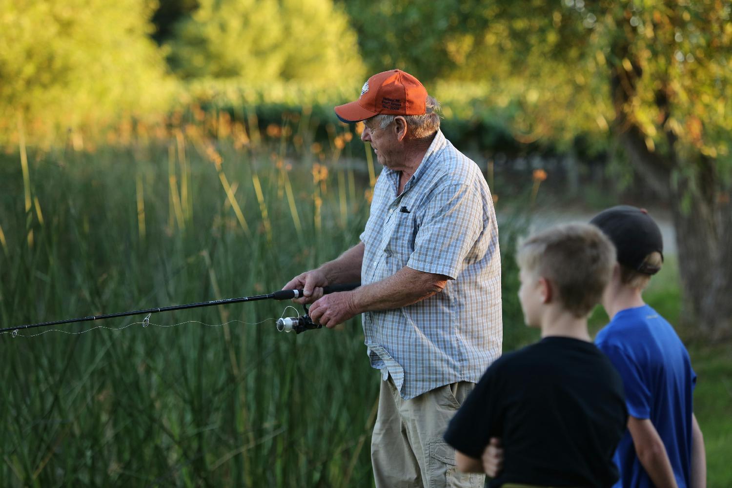 One of our long time tasting room employees at our Cakebread Cellars Family Picnic teaching younger generations to fish.