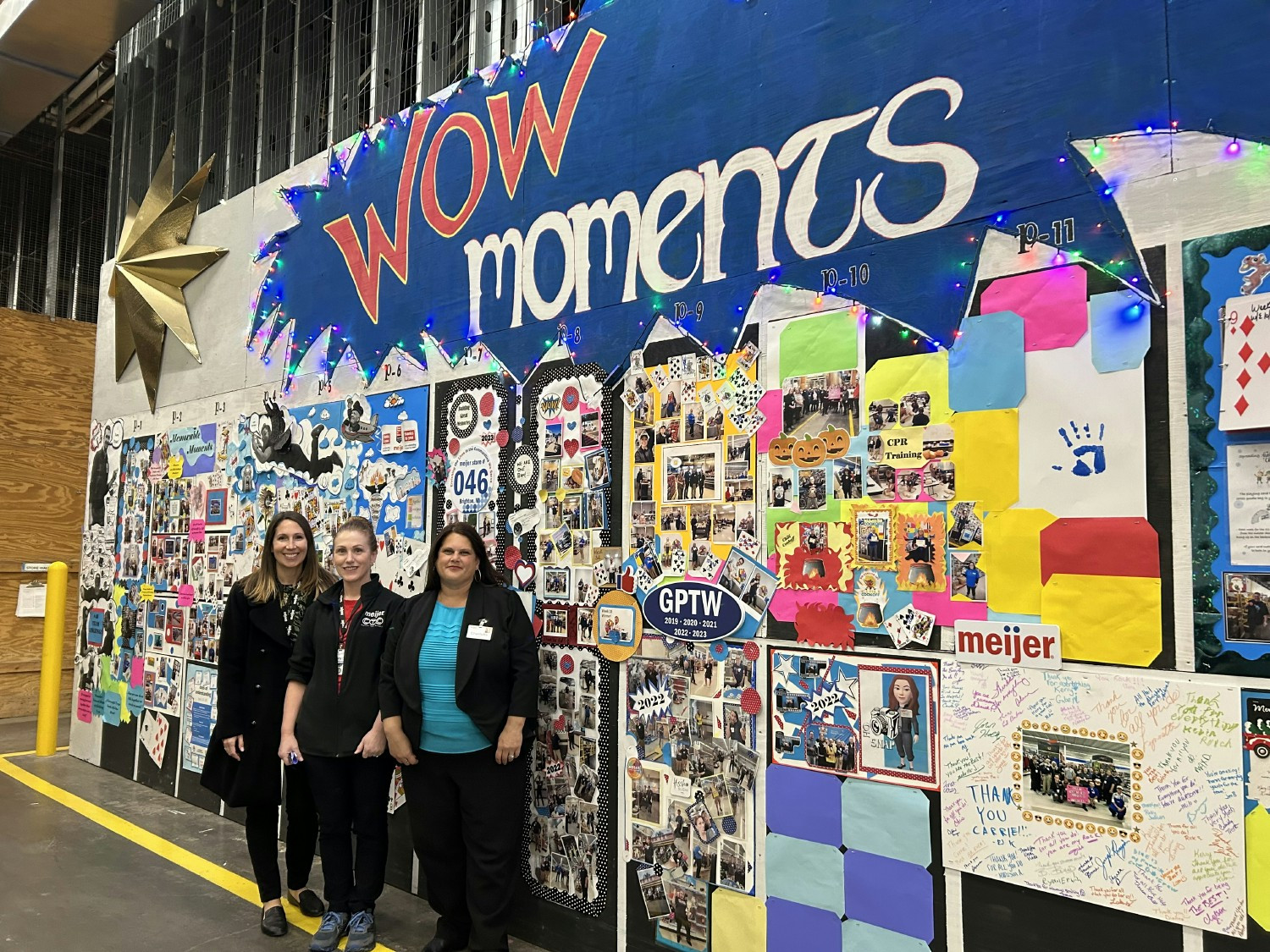 Team members at one of our stores showcasing the store's WOW moments wall. 