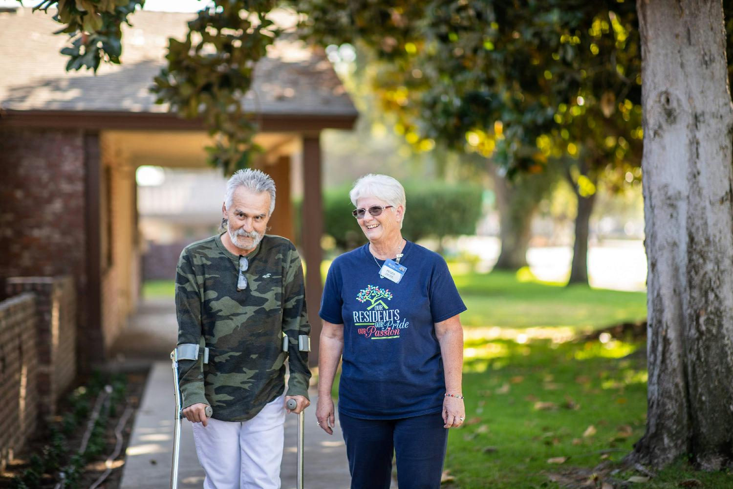 Eduro Healthcare employee escorts a patient outside after successful rehab treatments.