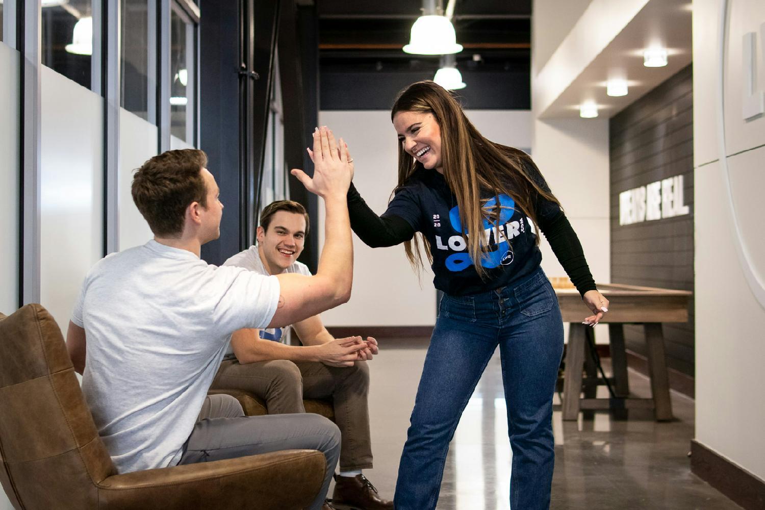 Two employees support each other with a high five.