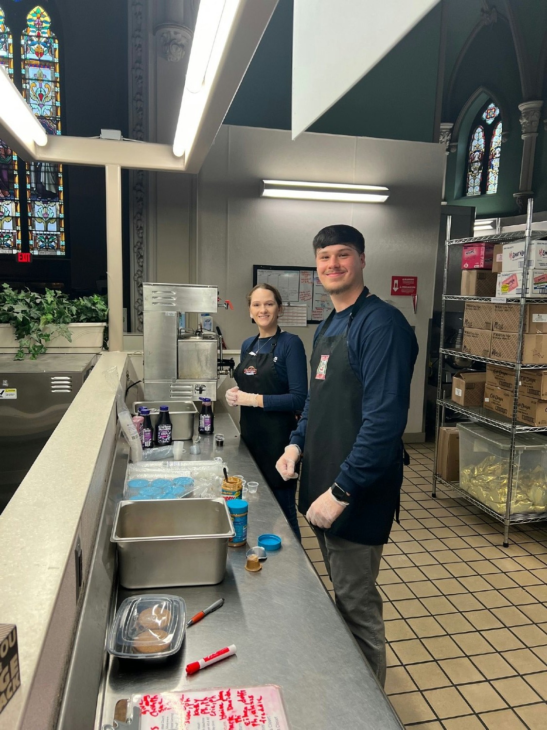 Employees lending there services to help serve a meal at a local soup kitchen