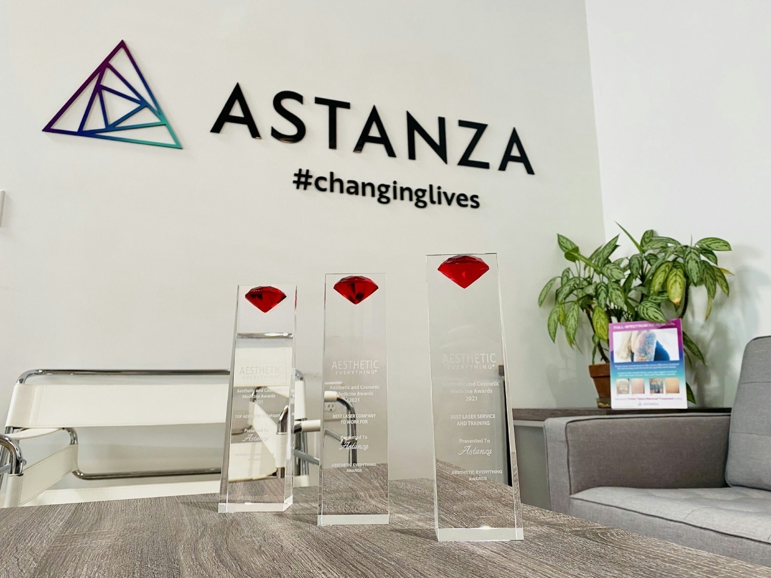 ASTANZA'S RECEPTION AREA FEATURING OUR LOGO, #CHANGINGLIVES MOTTO, AND A FEW AWARDS.