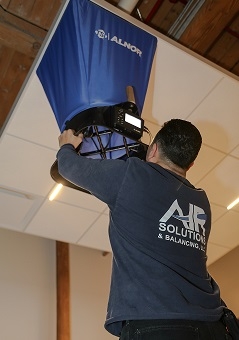 Air Balancing Technician performing our job with airflow hood.