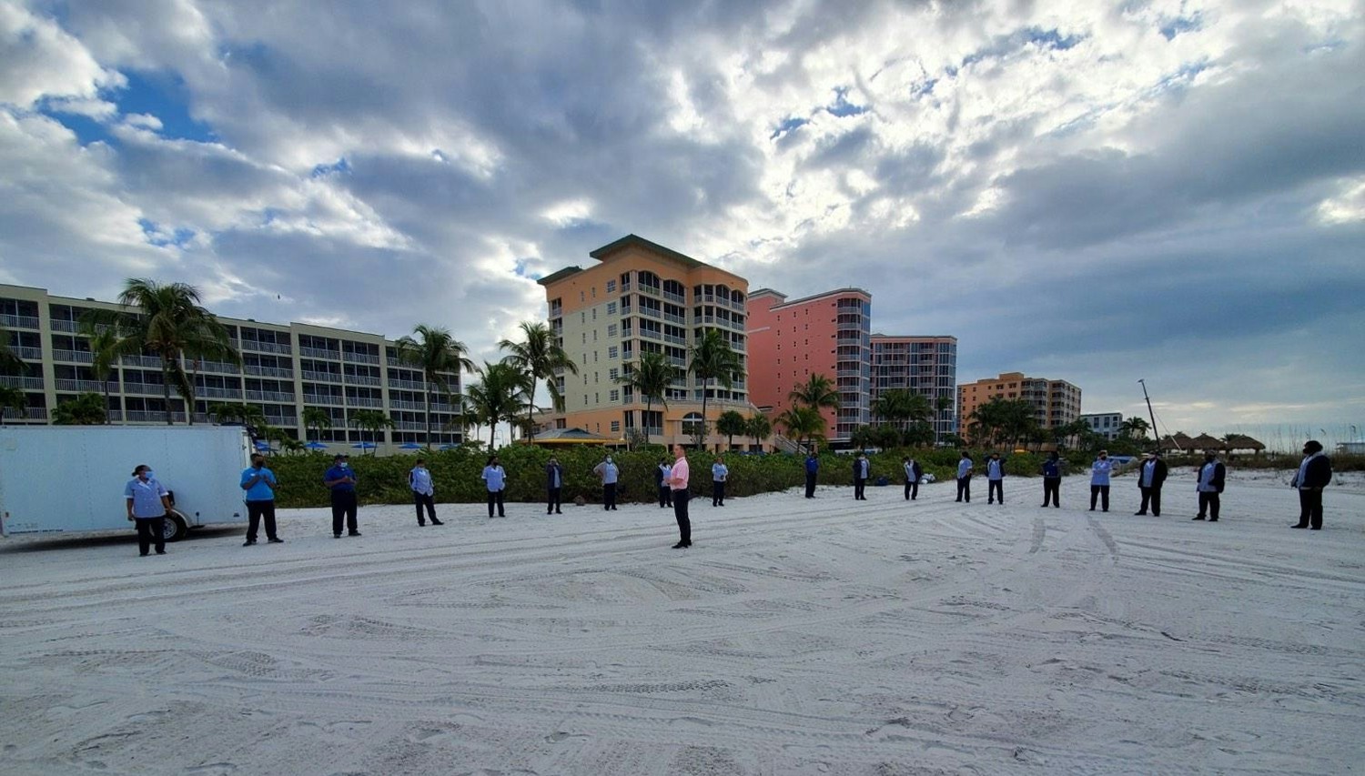 Housekeepers warming up with yoga on the beach.