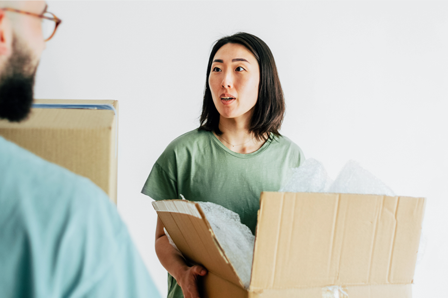  A woman in an office holds a box of her belongings after being let go