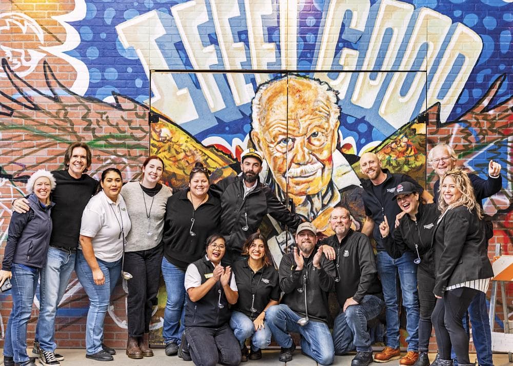  Employees at Nugget Market, No. 14 on the Fortune Best Workplaces in Retail™ list among large companies, stand in front of a graffiti mural of late chairman Gene Stille.