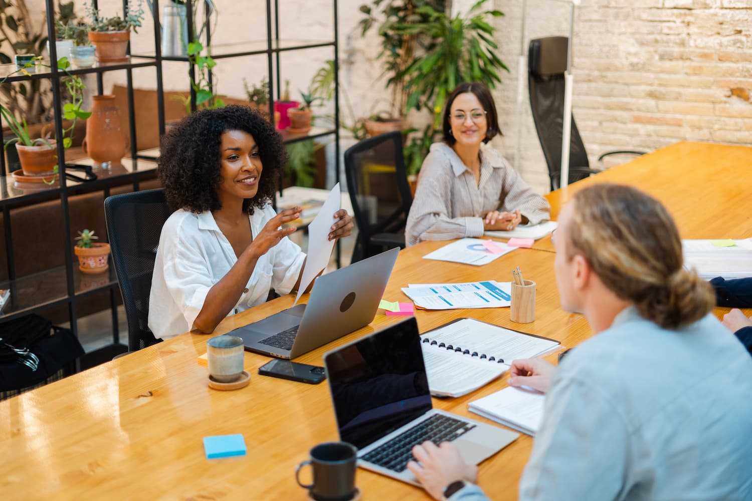  Woman talks with colleagues around the table at work