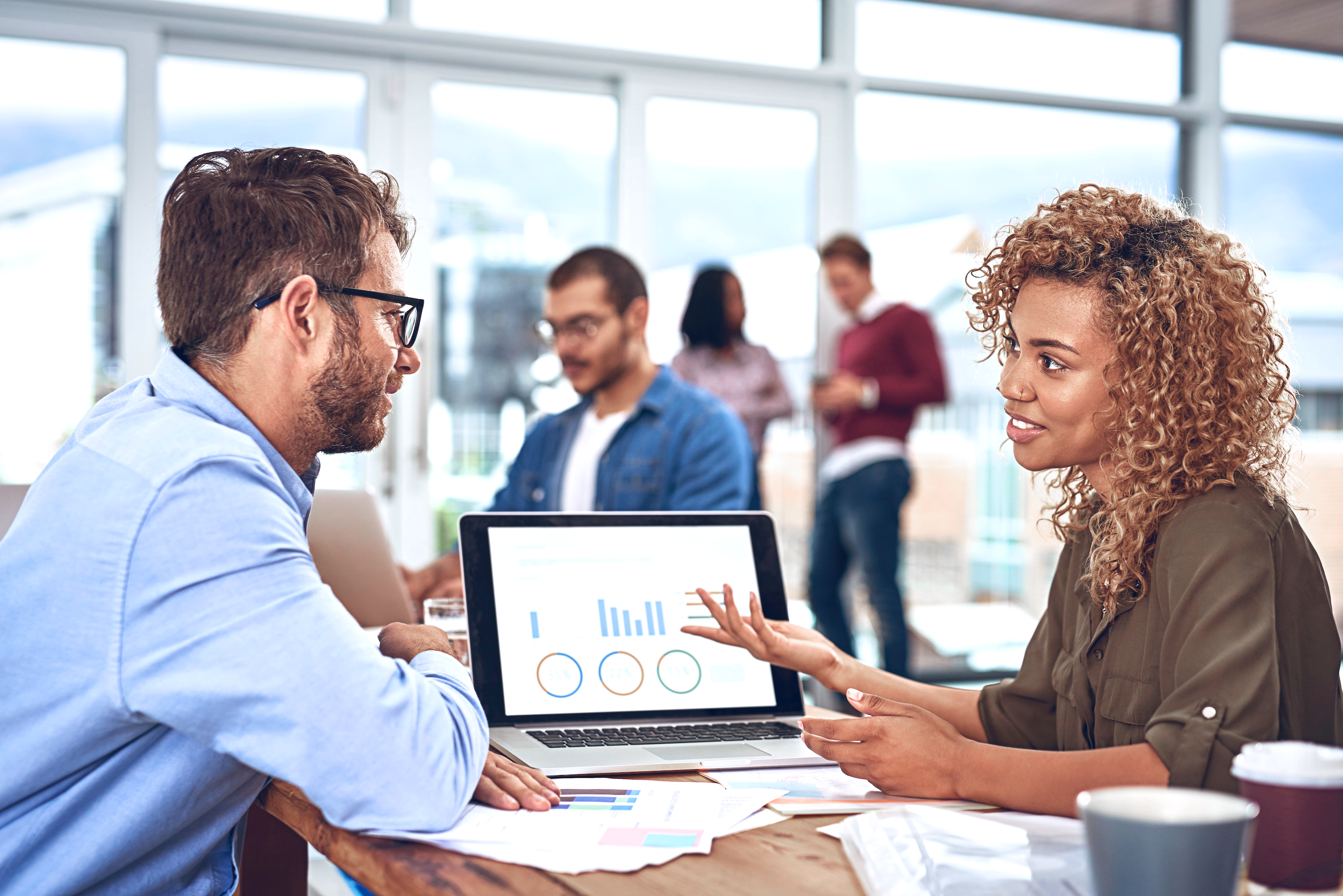  Woman pitches her business case for culture with data visuals on her laptop screen