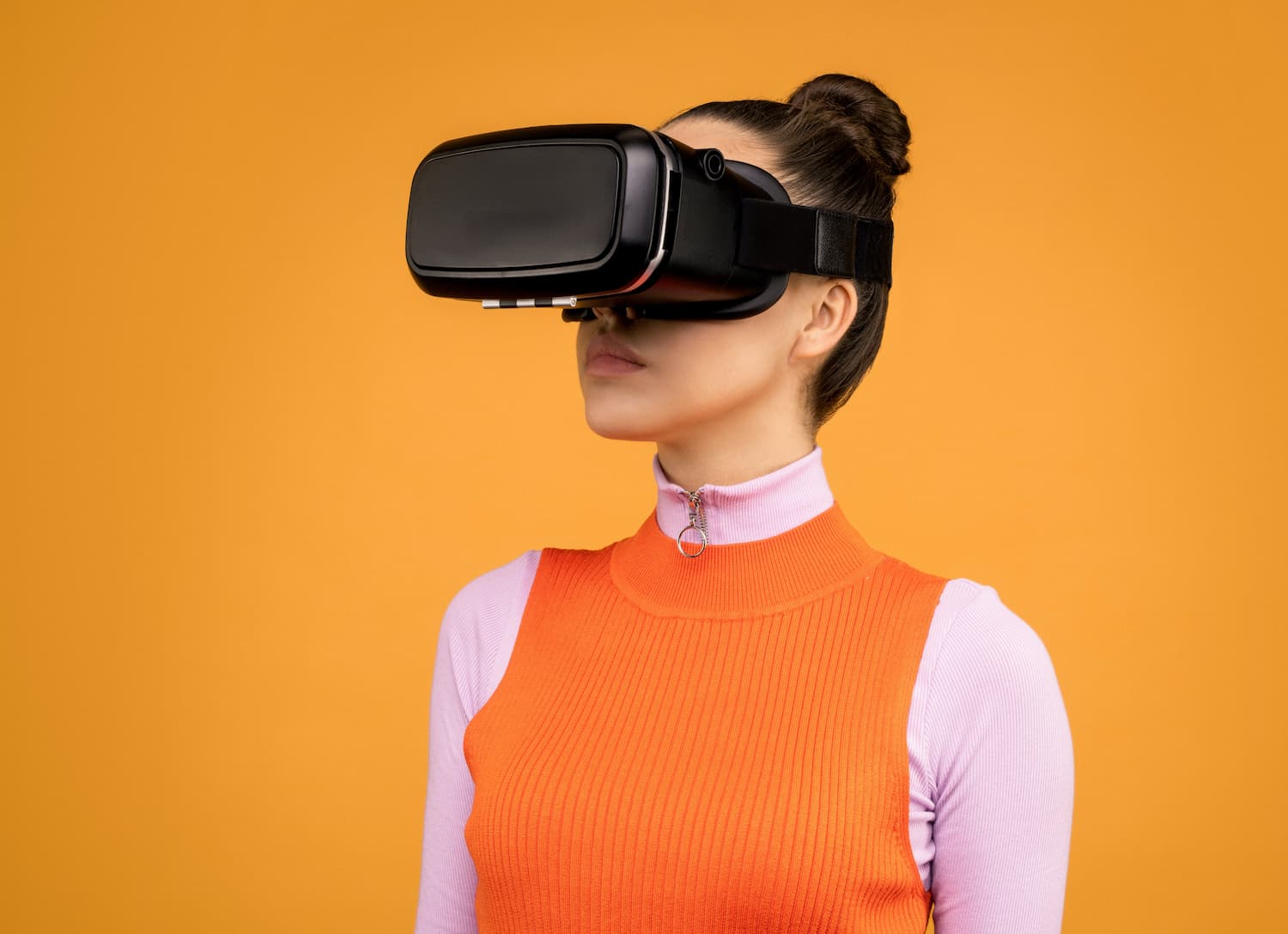  employee wearing VR headset in front of an orange background