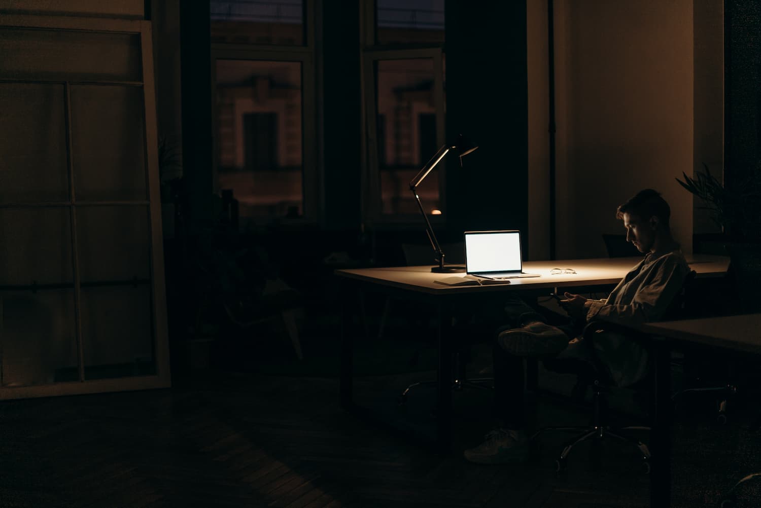  A worker sits alone at night in front of his computer