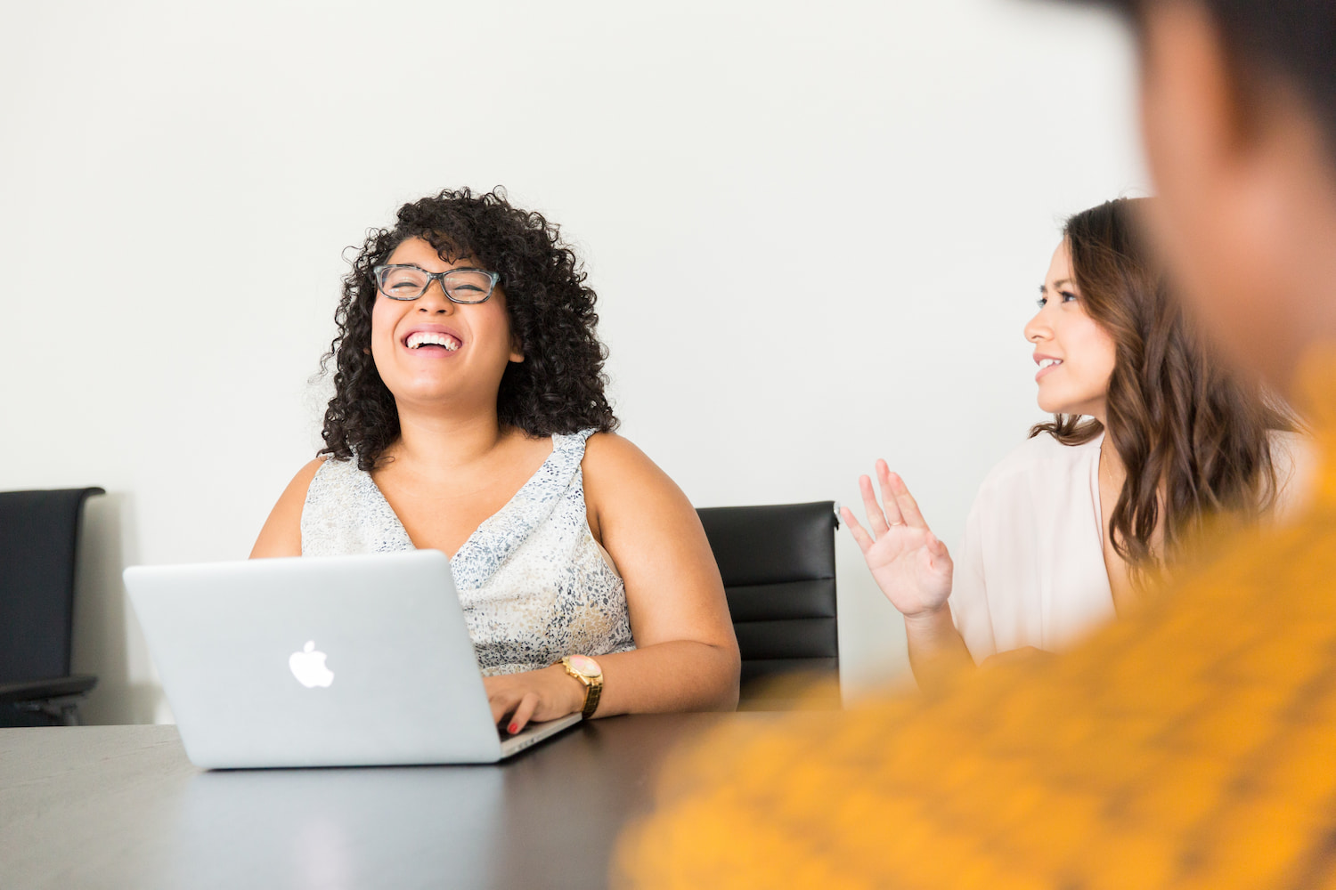  Smiling woman sits at laptop