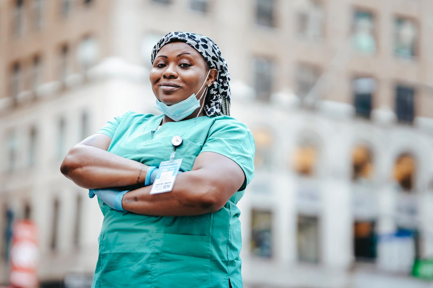  A nurse who works as an hourly employee stands in front of a hospital.