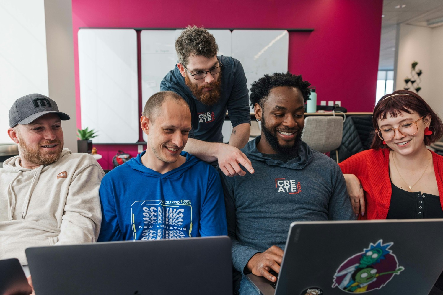  Return to office strategy is depicted with five employees looking at a laptop, and having a conversation about what they are seeing. 