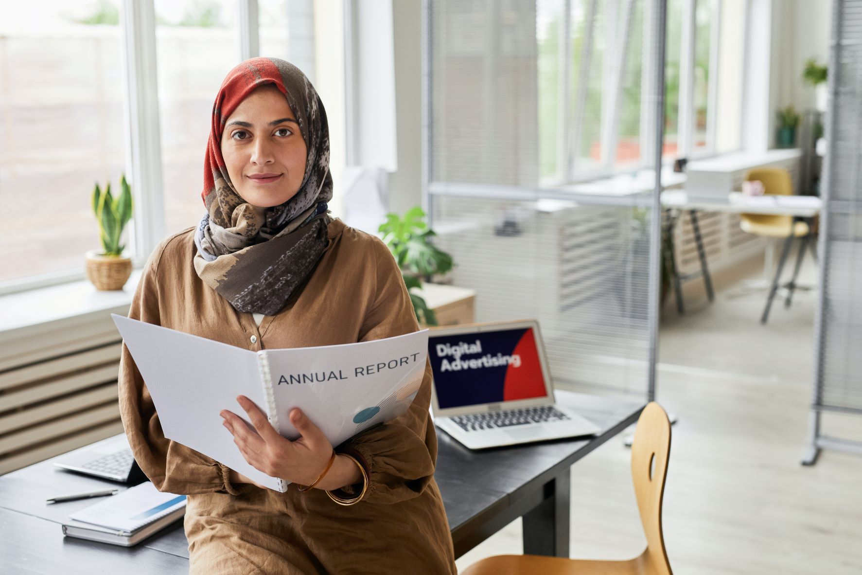  Employee sitting in an office with her workbook