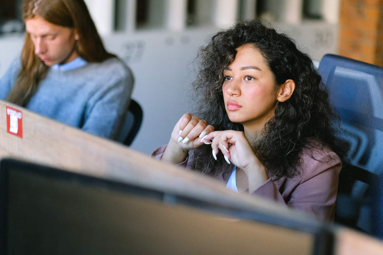  Young female employee looks away from her work