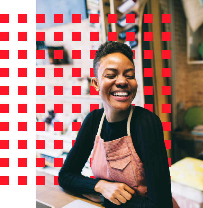 Workplace scene: woman smiling at table with red squares.