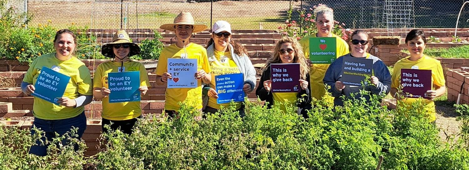 EY Connect Day participants show their love for volunteering at the Community Gardens of Tucson.