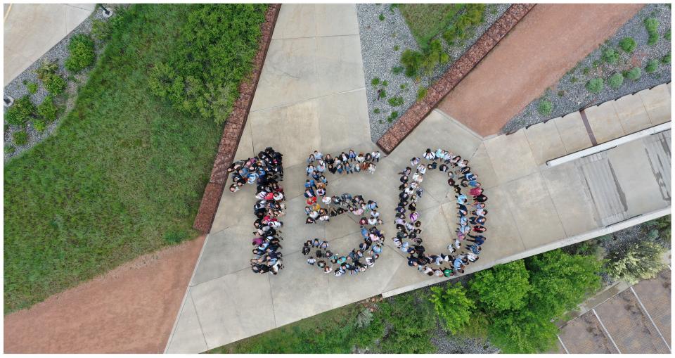 Goldman Sachs people celebrate the firm’s 150th anniversary with a commemorative photo.