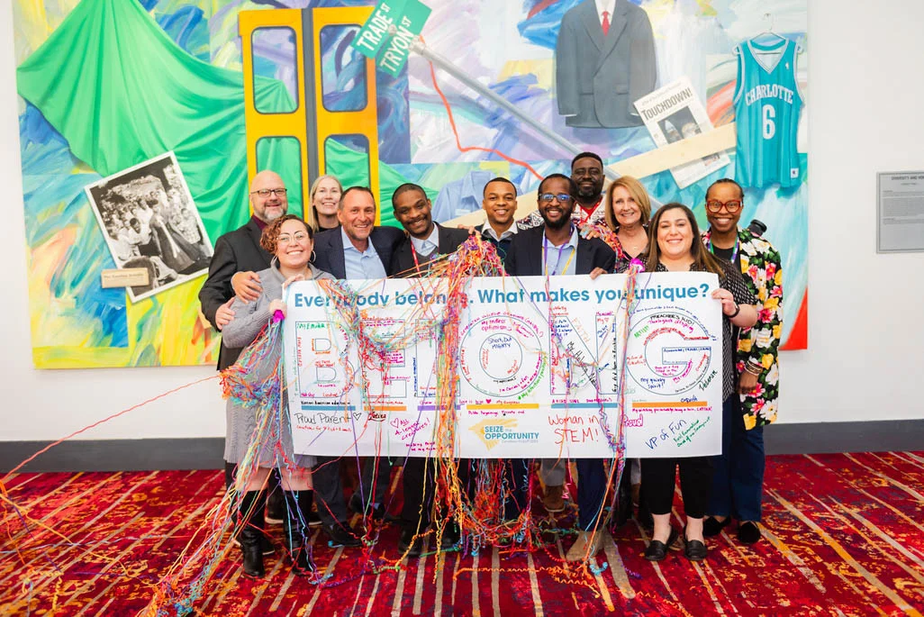 You belong here! Employees pose with our president and D&I leader at a regional meeting.