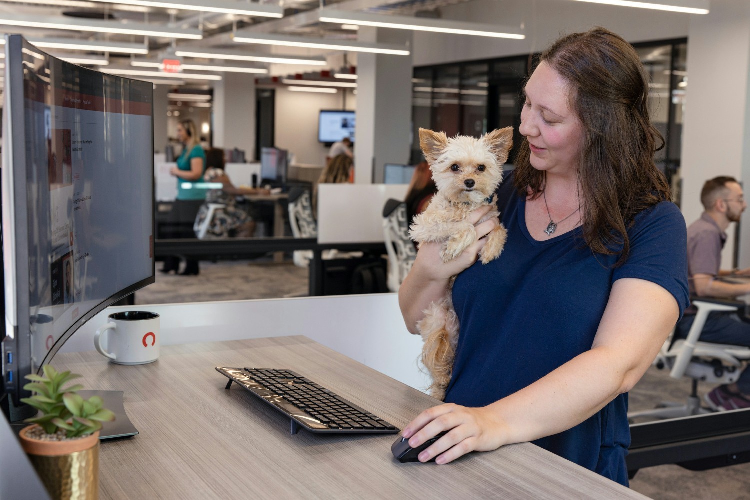 A team member works in the office with her pup at her side, courtesy of the Rocket Companies' Paws at Work program. 