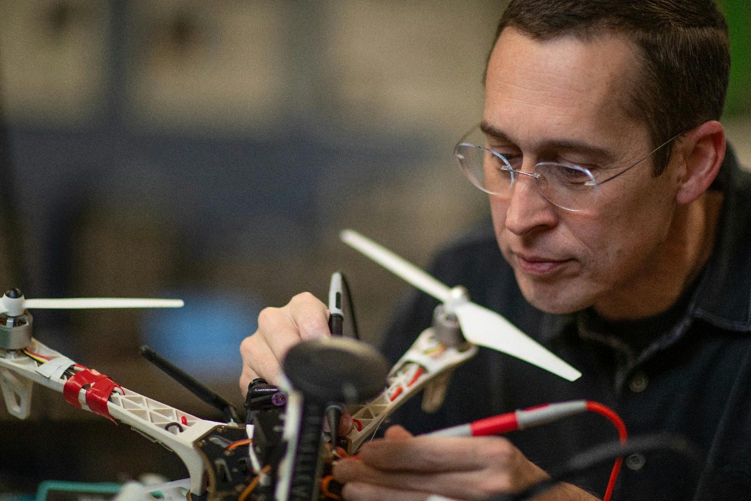Dr. Michael Balazs works on a drone, part of MITRE's robotics research.
