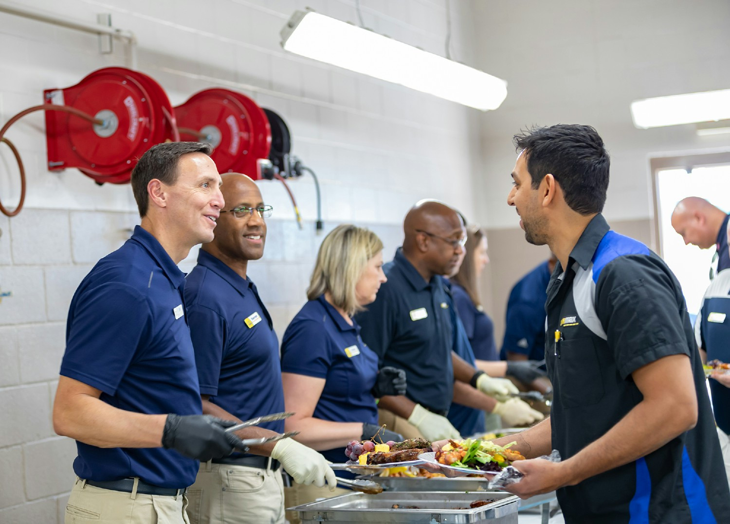 Leaders Bill Nash, Darren Newberry, and Corey Haire serve lunch to award winning Associates, including Aaron Puerta. 