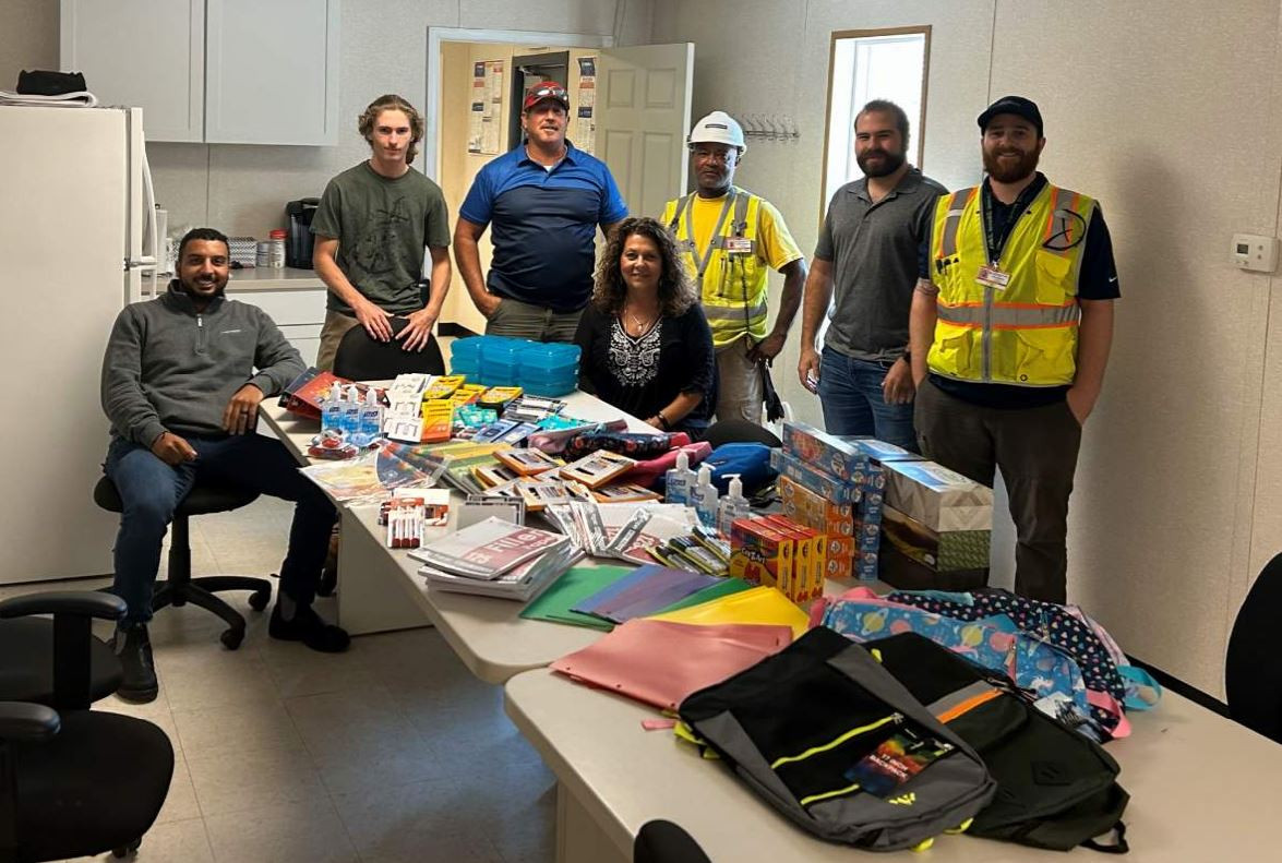 The Hampton Roads team displays donations for a backpack drive.