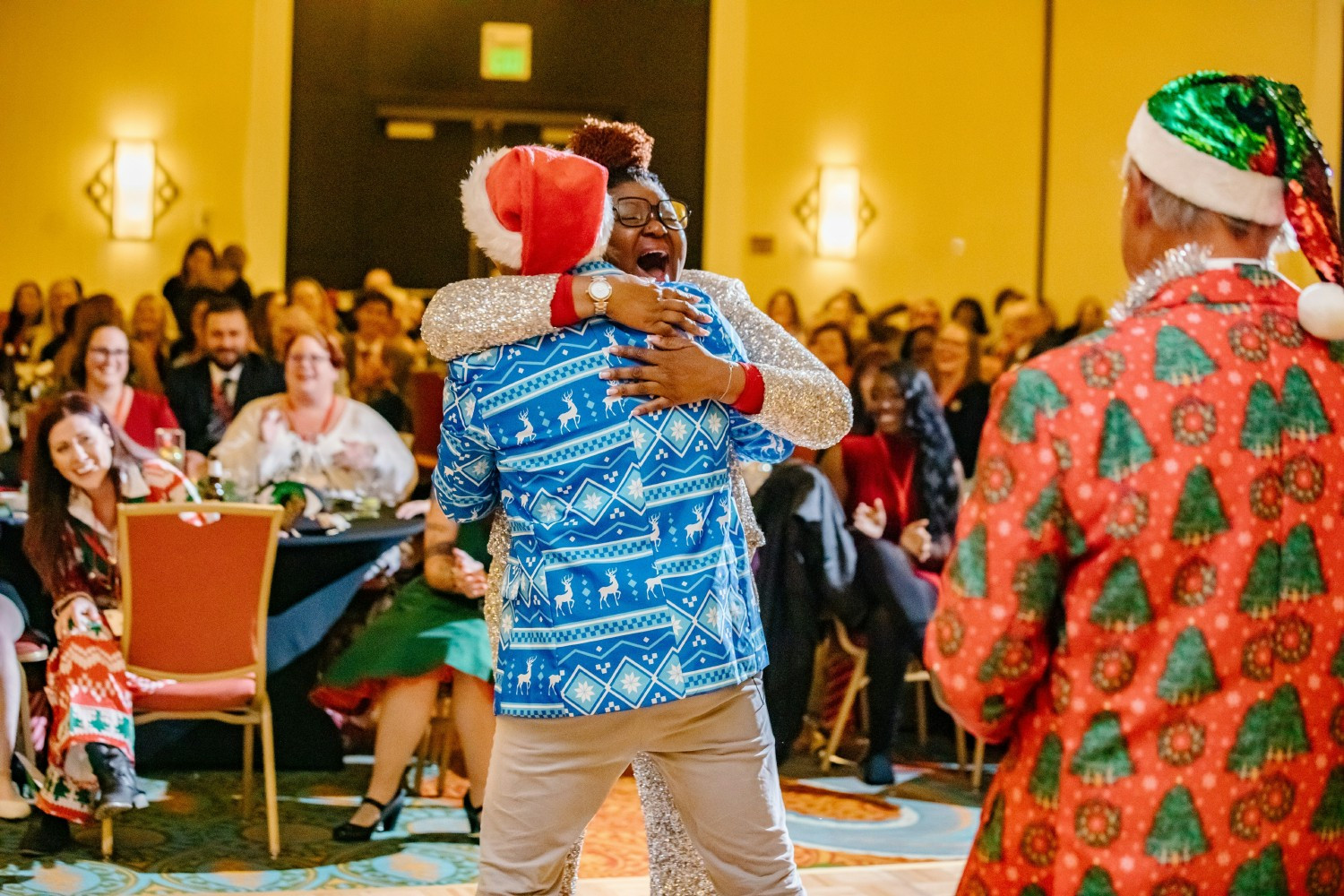 An officer hugging an employee who won a prize at our Annual Holiday Party.
