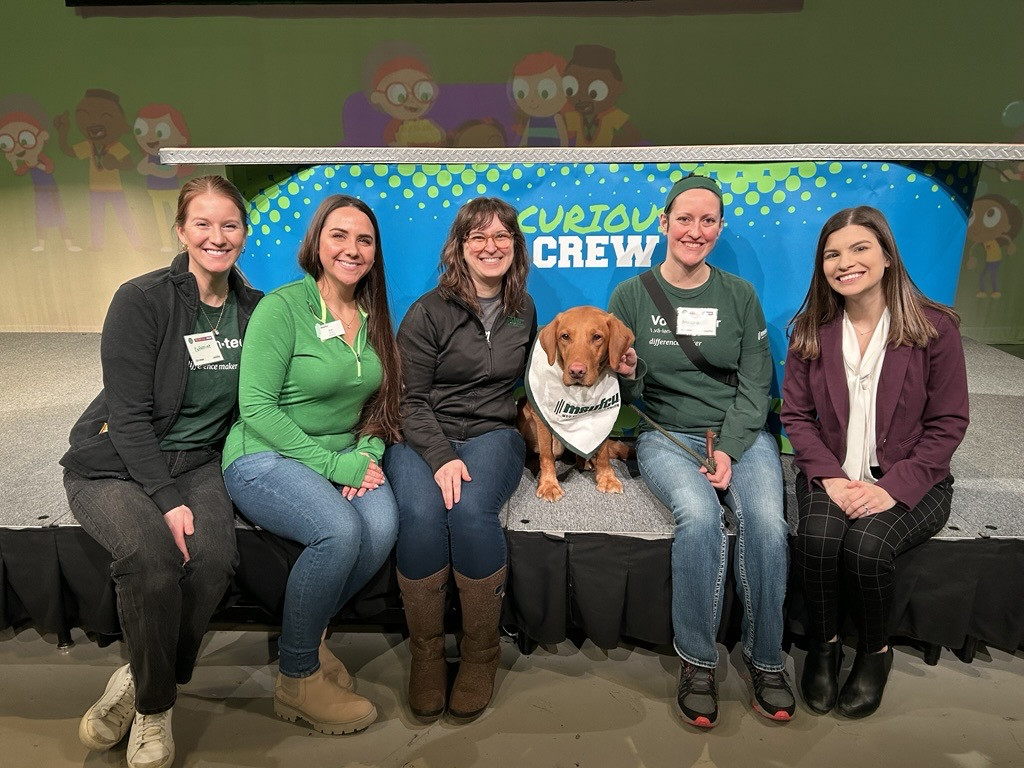 Employees volunteering at a local PBS Kids event, with Zeke the Wonder Dog!