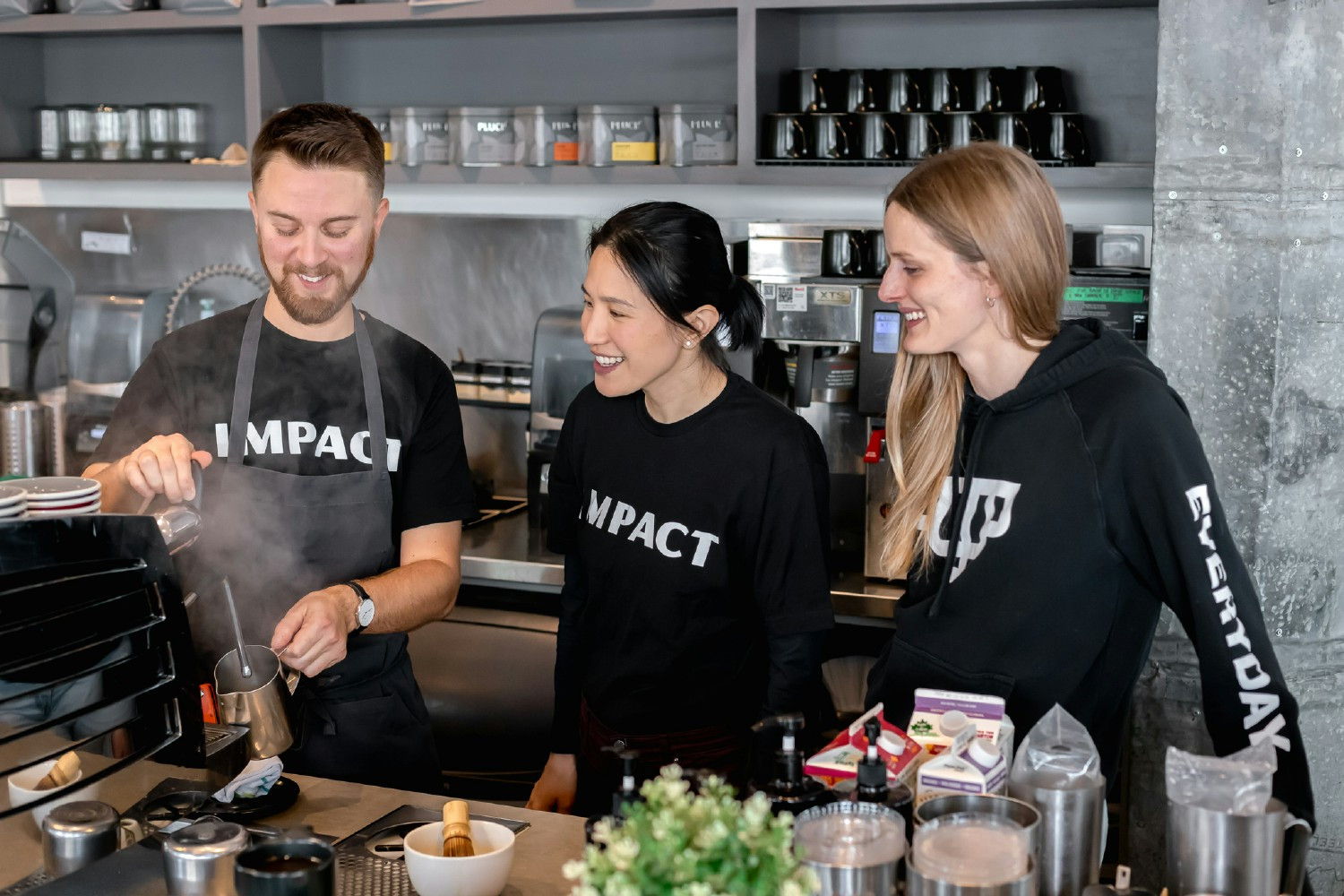 Barista training staff how to steam milk in location 