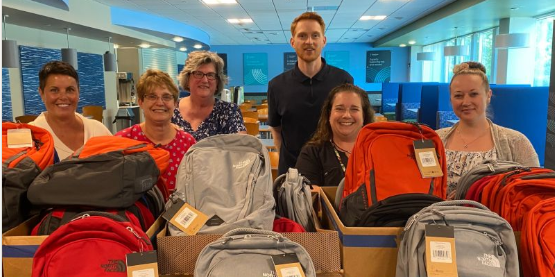 The US office packing backpacks of school supplies for Beverly Bootstraps to support local kids to start school prepared