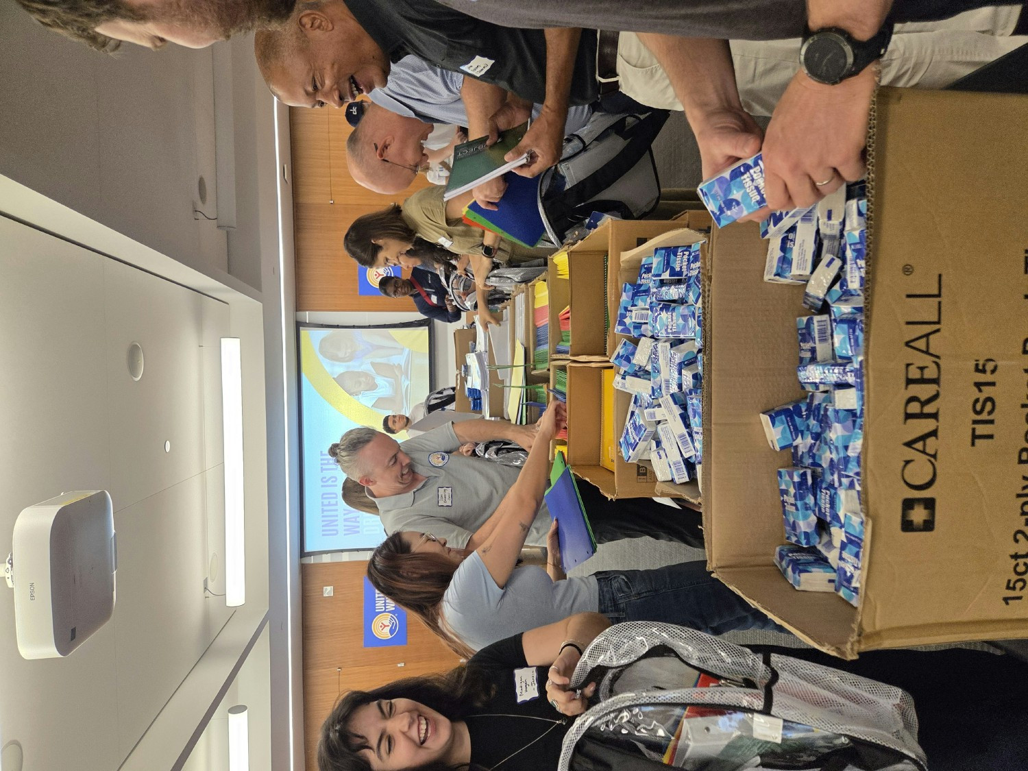 Janes US colleagues taking part in a United Way volunteering event, preparing backpacks with supplies for school kids