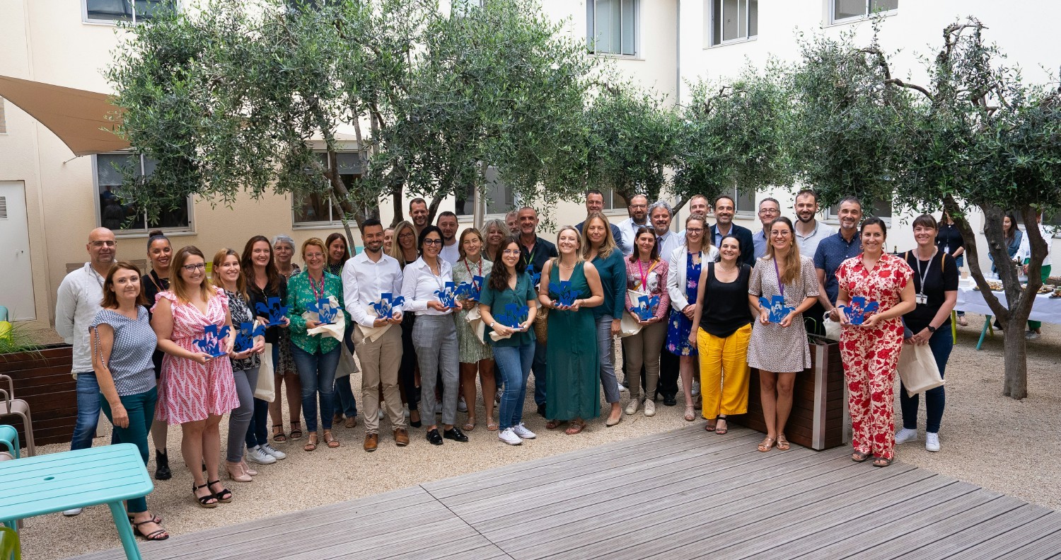 Celebrating 10 years: Employees receive a unique horse statuette by local artist Hervé Nys during ceremony with Execs.