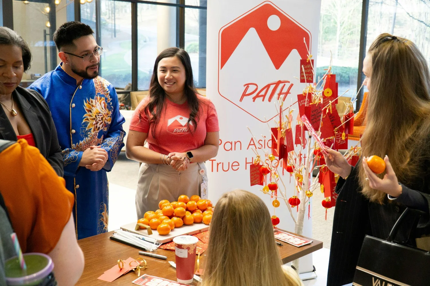 IHG colleagues celebrating Lunar New Year by gifting mandarin oranges and writing wishes on the wishing tree.