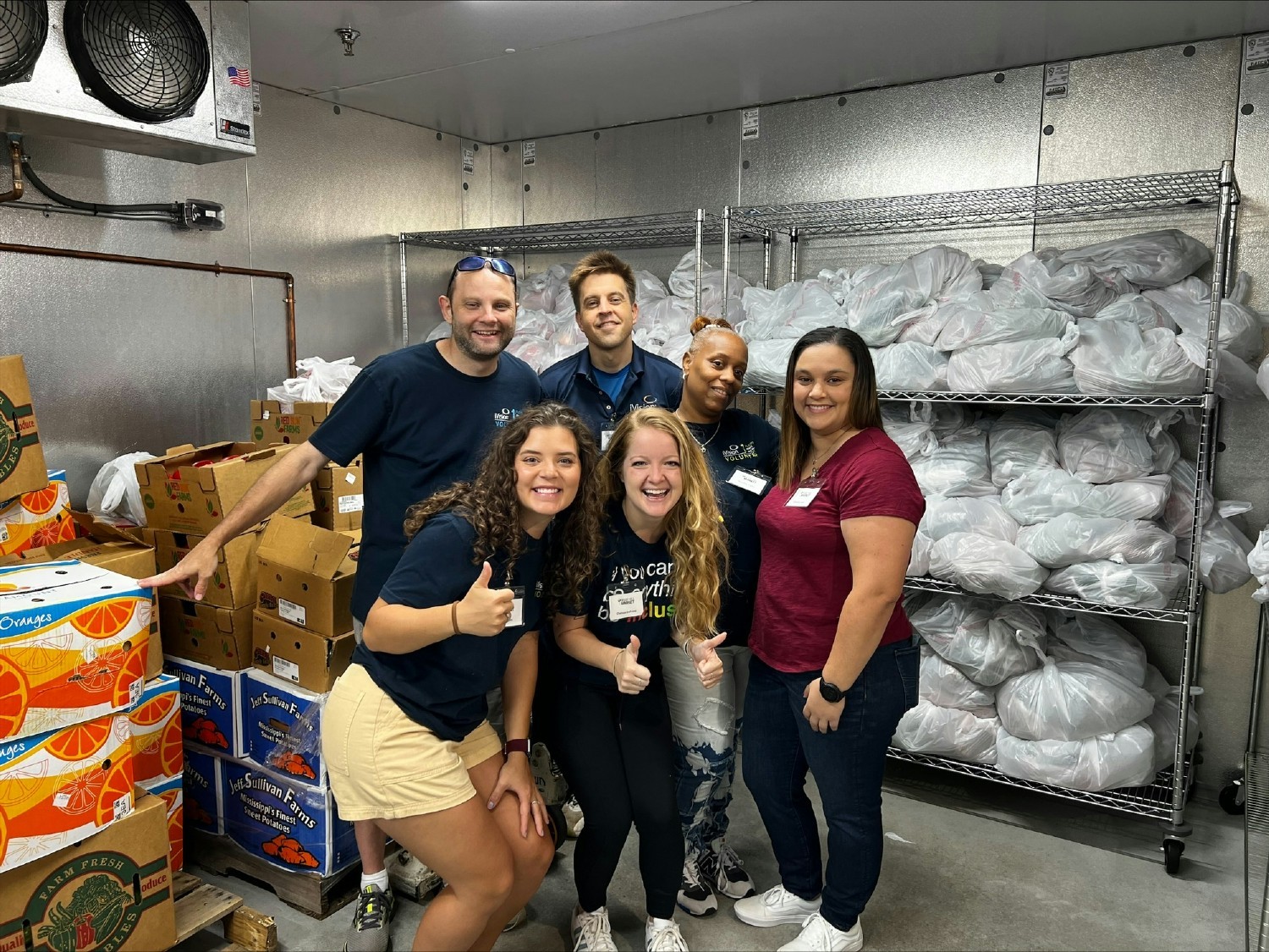 Team members volunteer at a Georgia food pantry to pack and organize over 260 bags of fresh produce and food.