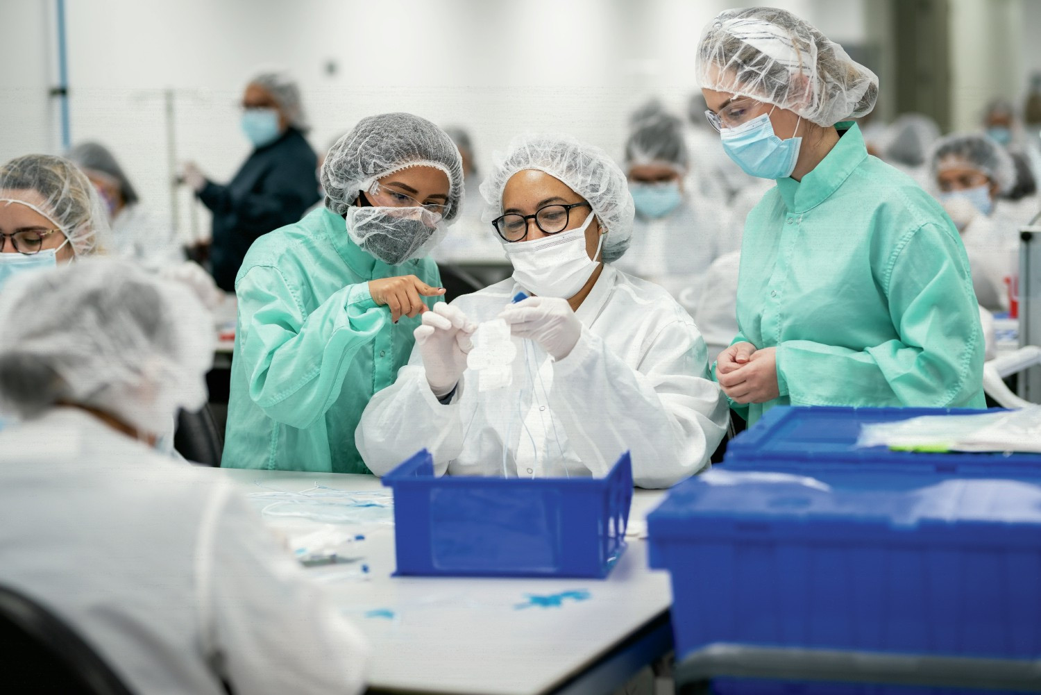 Arthrex Manufacturing Inc. Suture employees discuss placement of the suture on a card to prepare it for packaging.