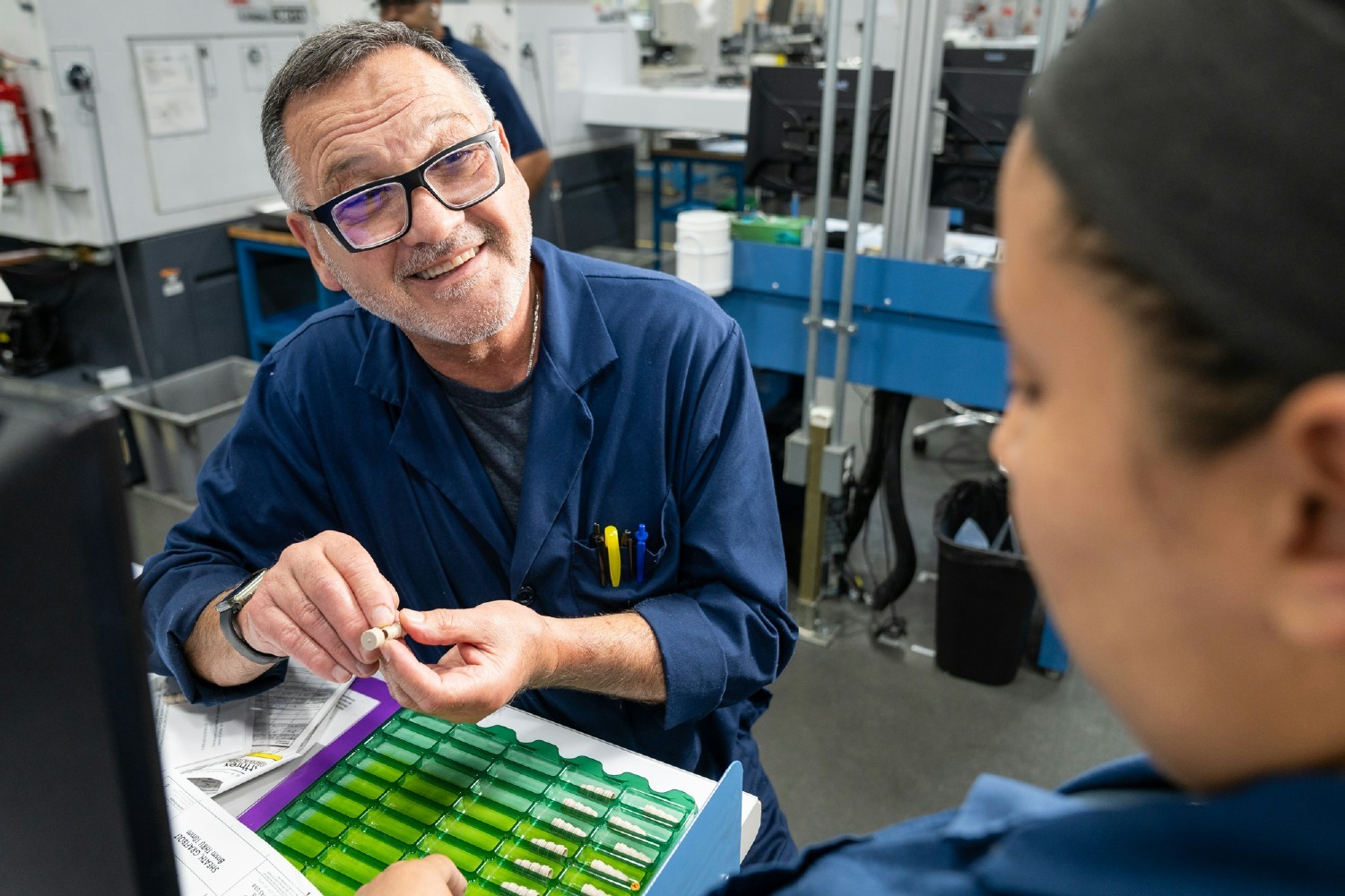 Machine Operator I Ramiro Lesmez inspects GraftBolt® pieces during his shift at Arthrex Manufacturing Inc. East.