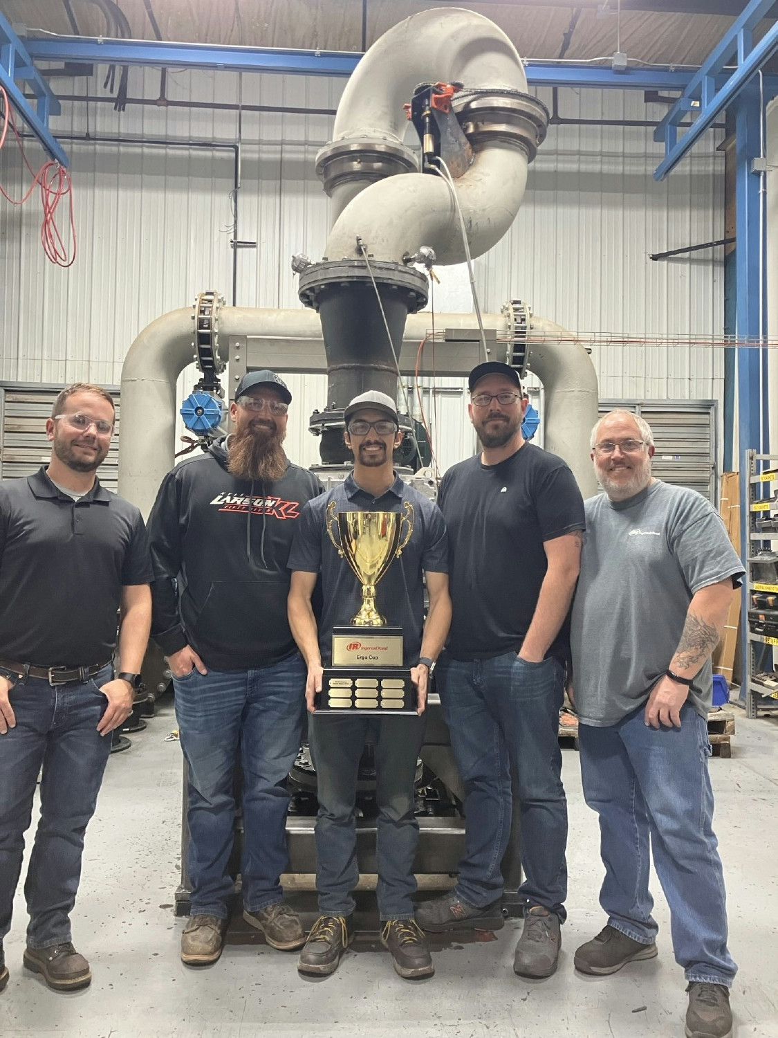 Team members in Sedalia, MO proudly hold the Ergo Cup trophy for the best project to eliminate ergonomic risks.