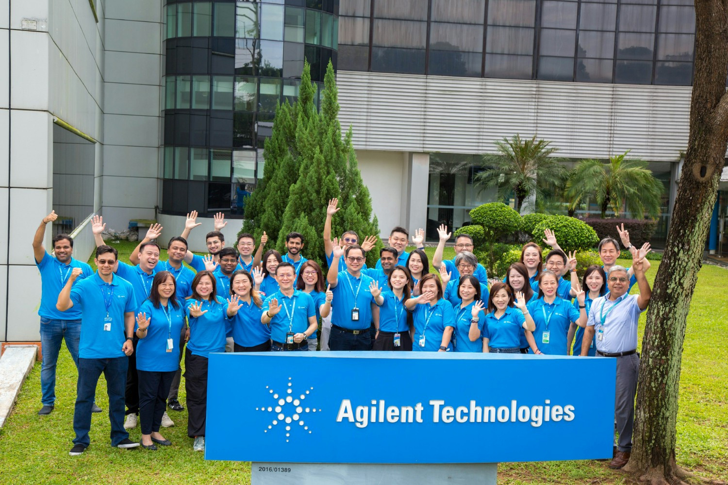 Employees gather to represent the Agilent “Spark of Insight” logo during a company celebration. 