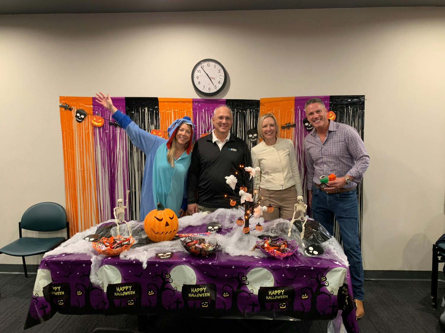 Members of the Senior Leadership Team pass out candy for associates and their families at a Trick-or-Treat event