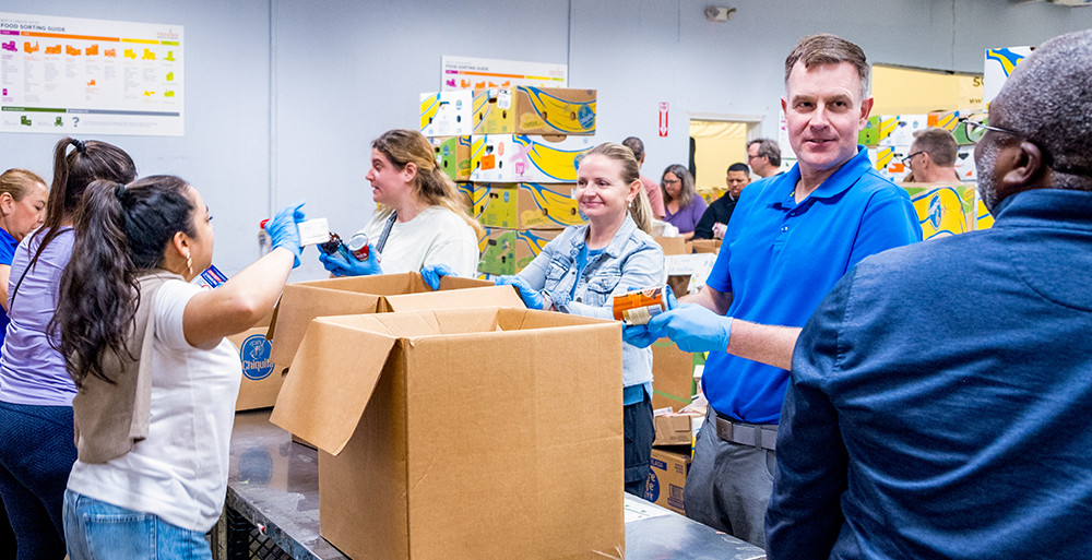 The corporate team packing donations to support individuals and families experiencing food insecurity in Miami