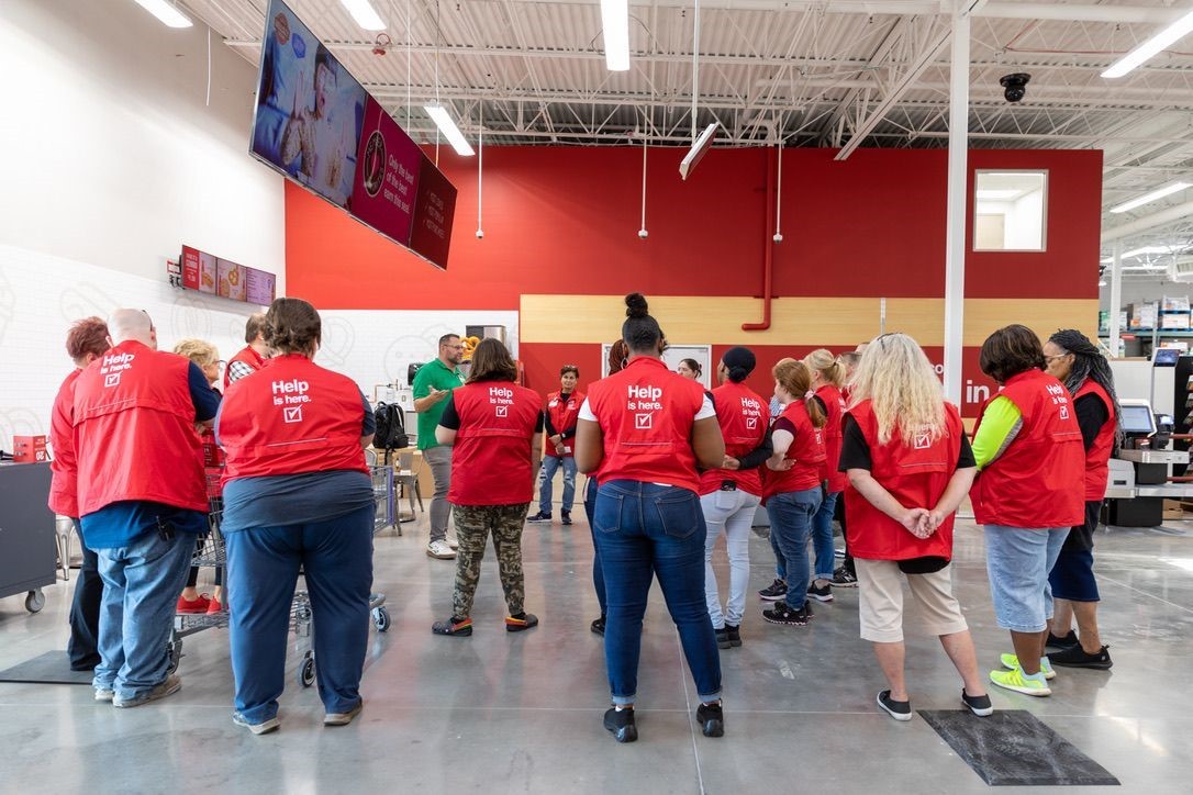 Club team members huddle around their leader during a morning huddle where they give recognition and align on priorities