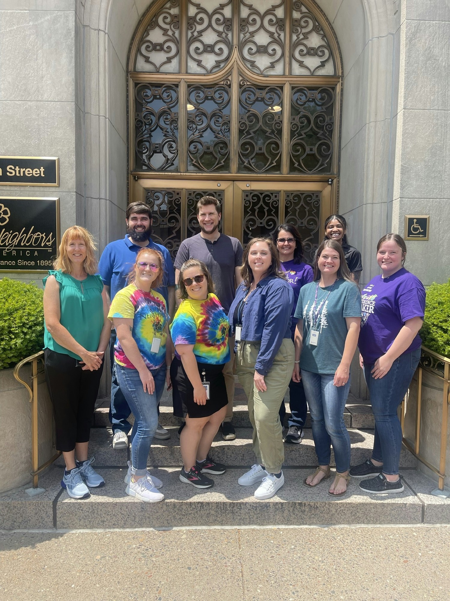 Employees posing in front of the home office, preparing to get their steps in during the health and fitness walk.